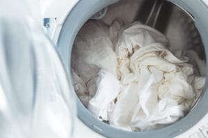 White clothes in washing machine. Open door.